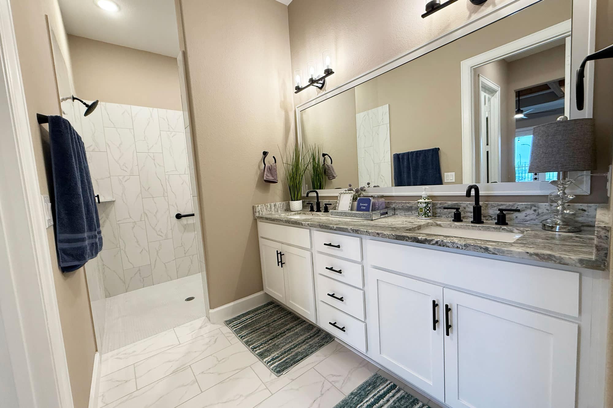 Primary bathroom with double vanity and walk-in shower in a Winfrey Estates home