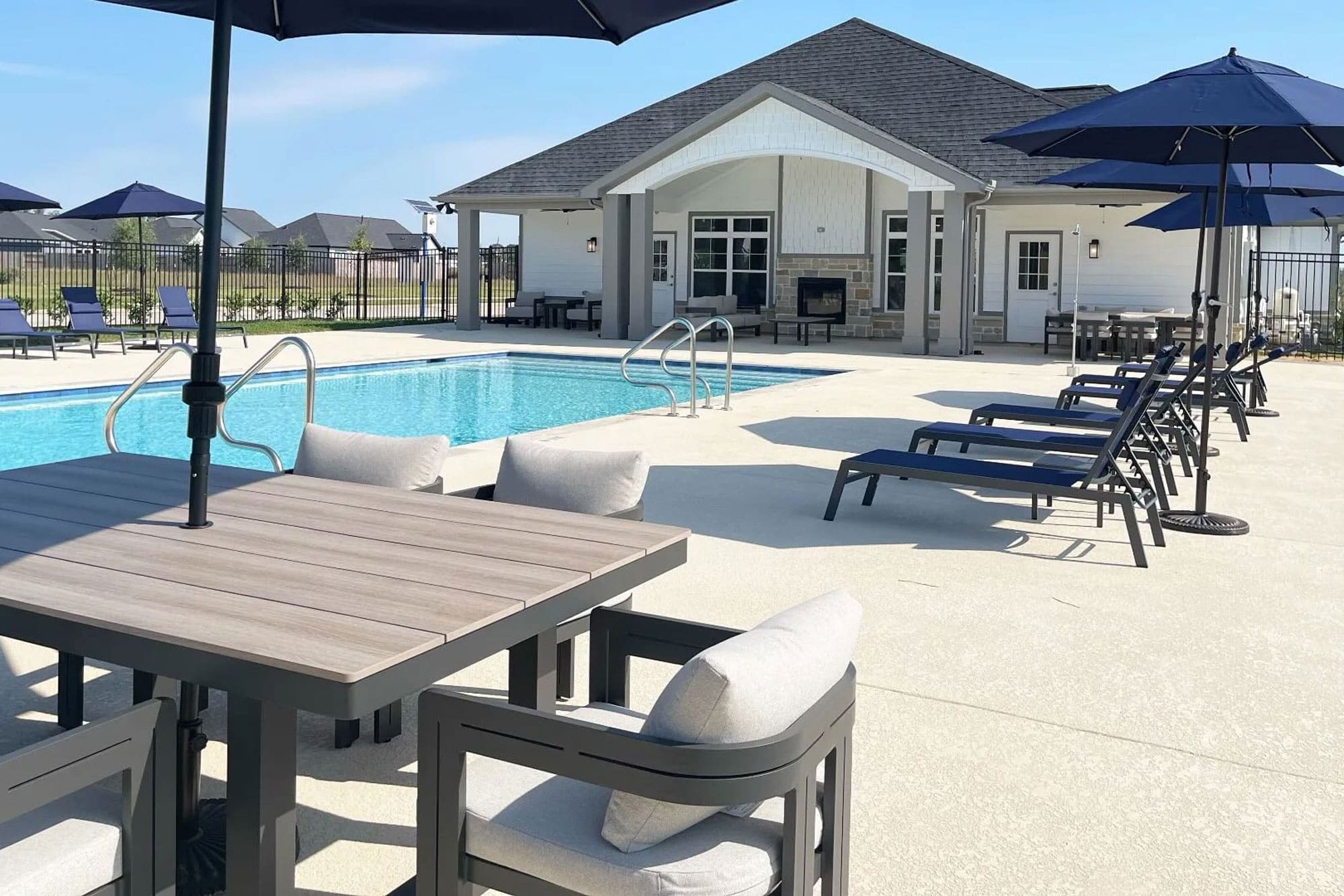 Covered patio seating beside the pool at the Winfrey Estates clubhouse in Tomball, TX